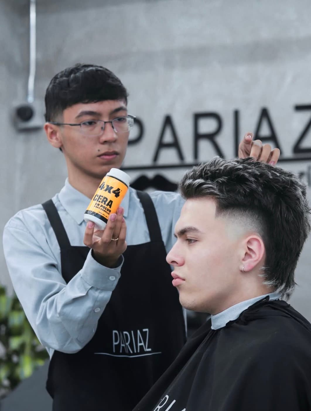 Barbero presentando cera en polvo 4x4 para el cabello